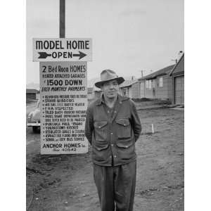 Unidentified Man Standing in Front of Sign for Model Homes Being Built 